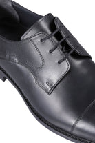 Black leather dress shoe with a polished finish and classic lace-up design.