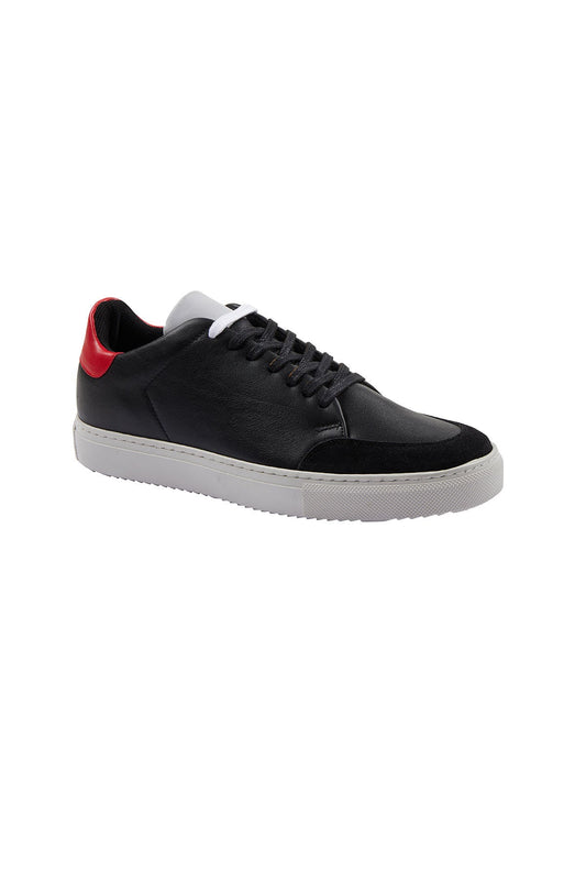 Black leather sneaker with a red heel tab and white laces, featuring a contrasting suede toe cap and a chunky white rubber sole.