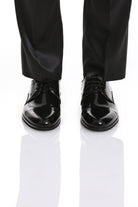 Black patent leather dress shoes with a glossy finish and classic lace-up design.