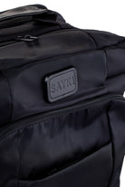 Black sayki backpack with quilted fabric and a leather-like brand patch.