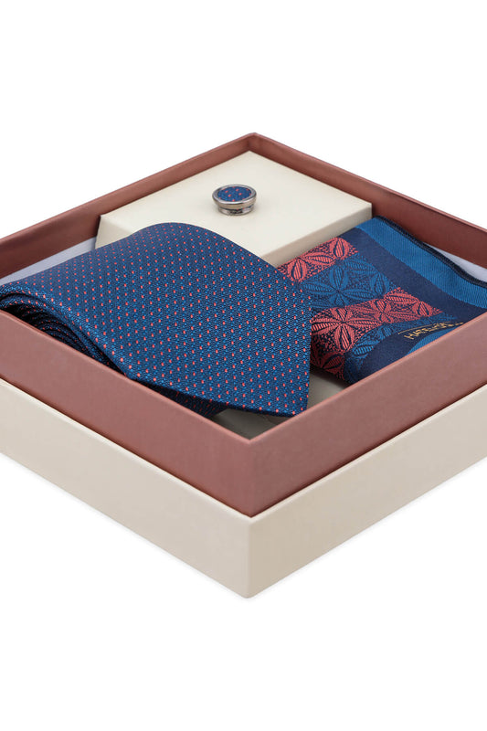 Blue patterned tie with fine red dots neatly folded in gift box part of pocket square and lapel pin set