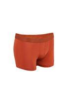 A pair of rust-colored, seamless boxer briefs with a matching elastic waistband featuring the brand name ’stay’ embossed on it.