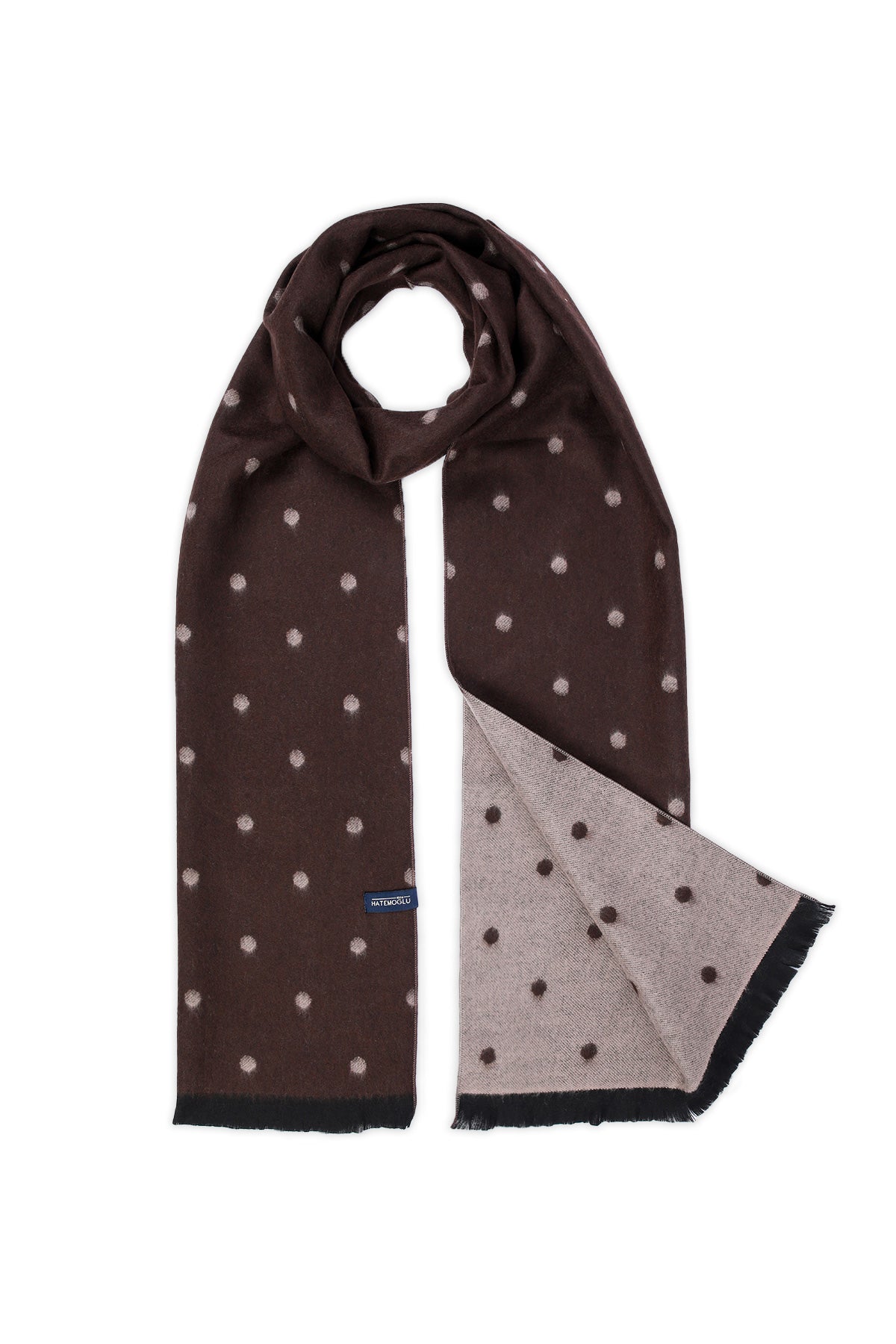 Brown scarf with white polka dots, featuring a contrasting light gray reverse side and black fringed edges.