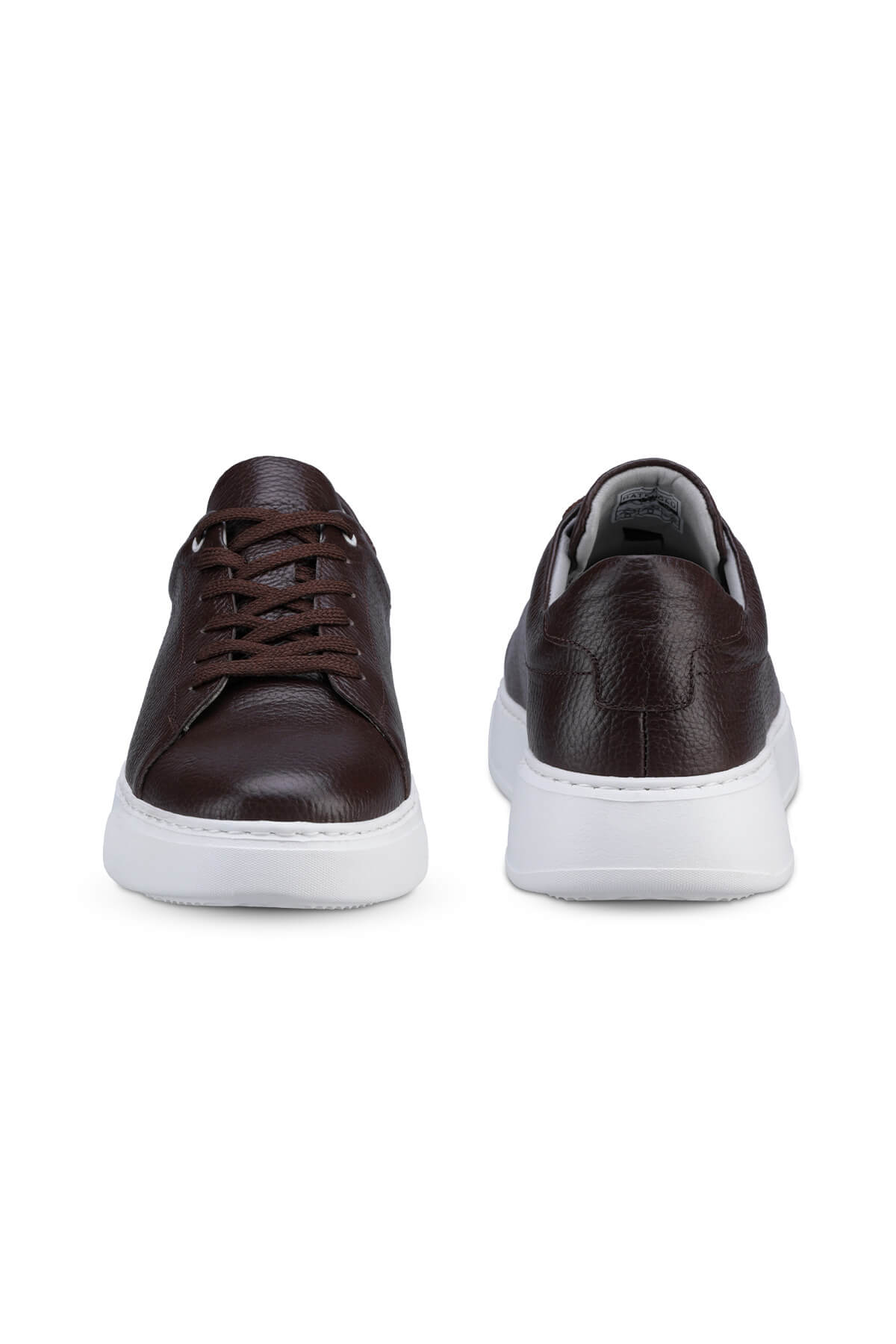 Brown leather sneakers with white rubber soles and matching brown laces.