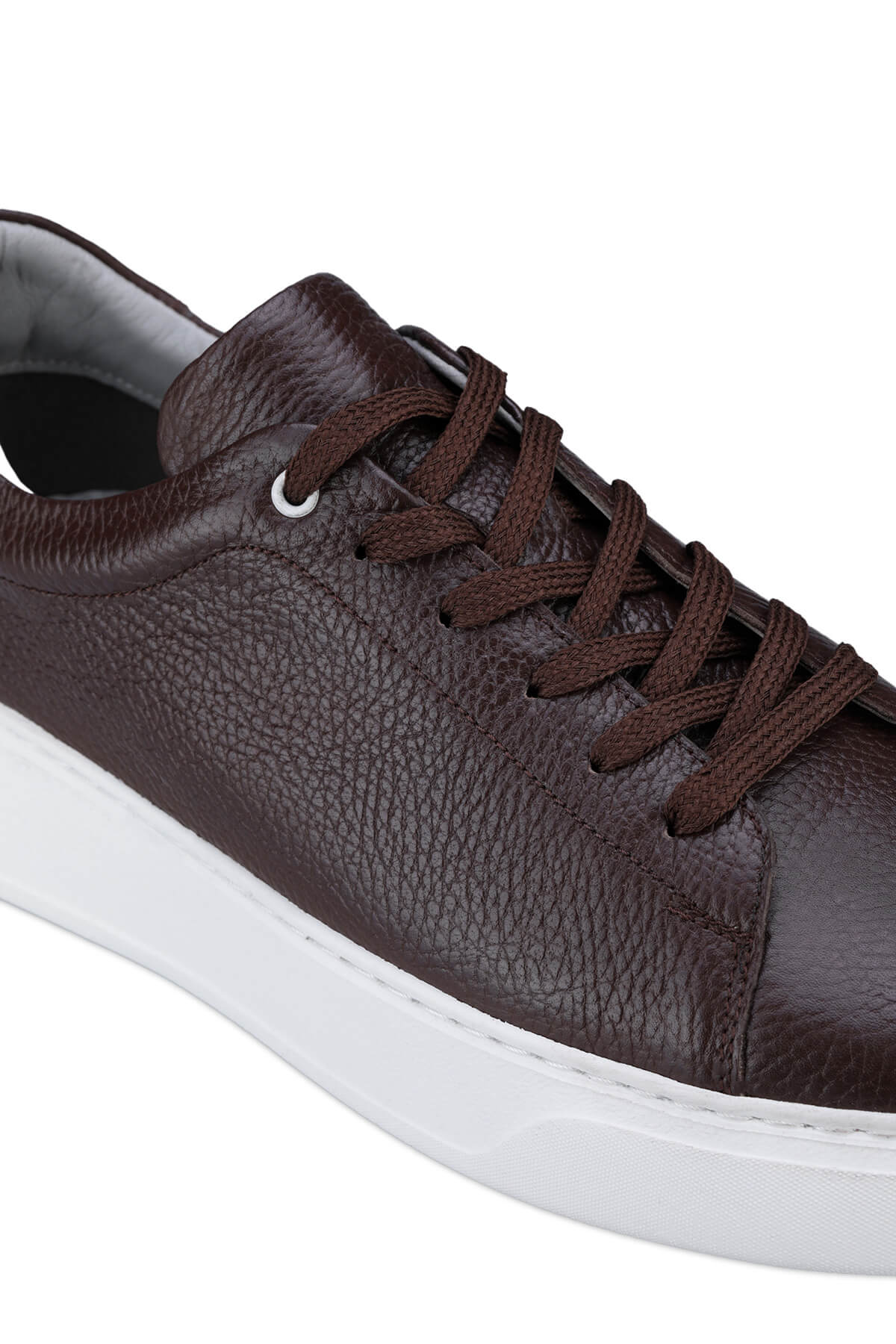 Brown leather low-top sneaker with a white rubber sole and matching brown laces.