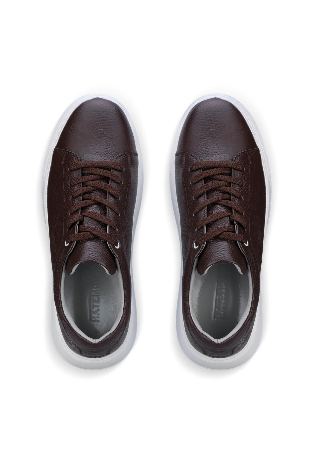 Brown leather sneakers with white soles and matching laces.