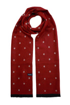 A rich red scarf with a subtle pattern of small, light-colored embroidered dots and black fringed edges.