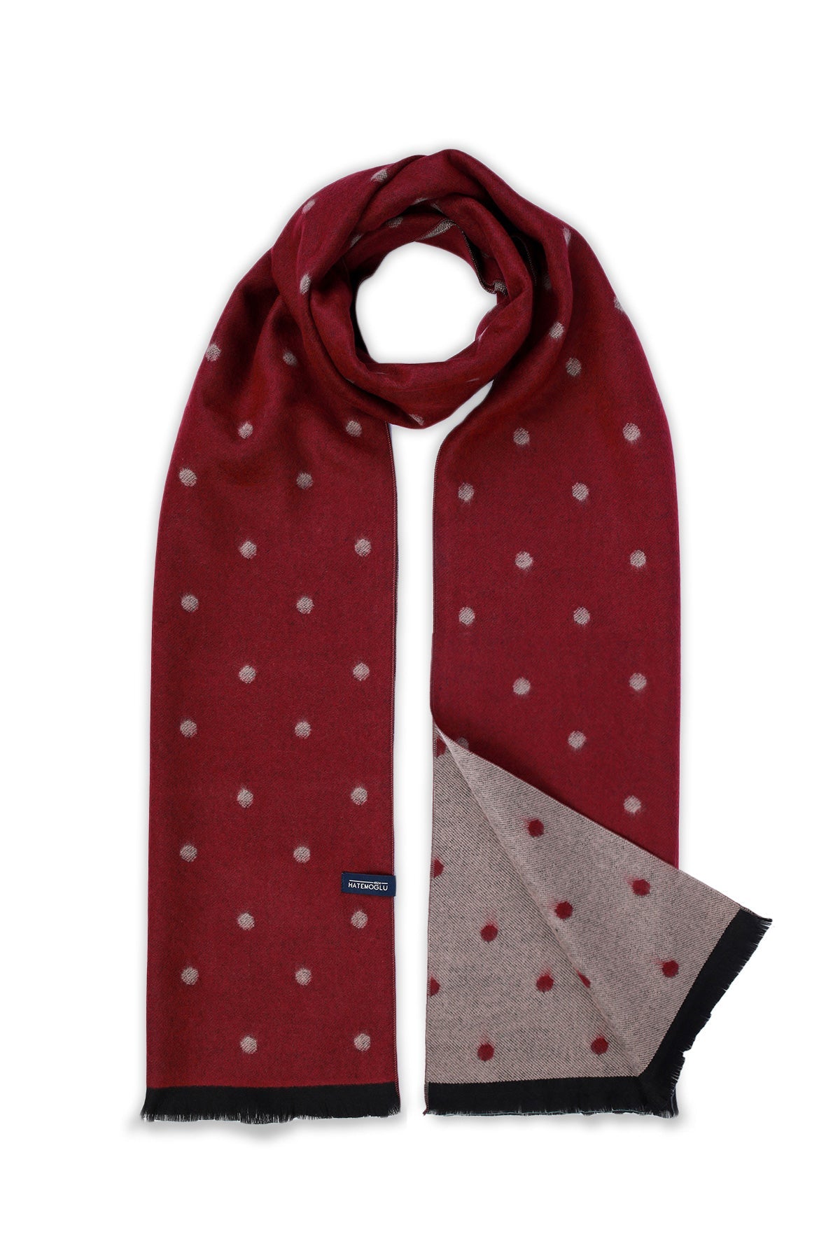 A rich burgundy scarf with a subtle pattern of small, light-colored polka dots and black fringed edges.