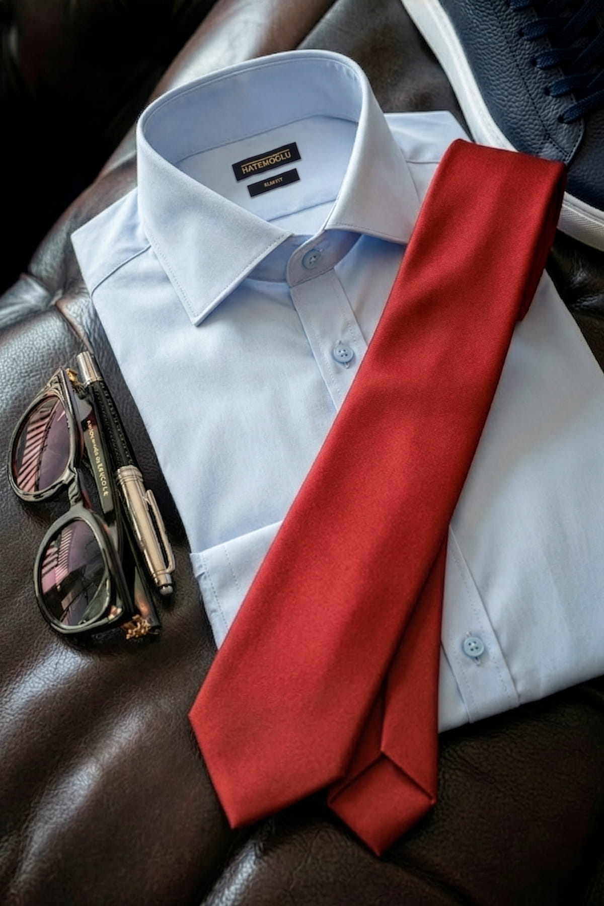A vibrant casual 2.36 inches red tie made of smooth micro polyester lies folded over a light blue dress shirt