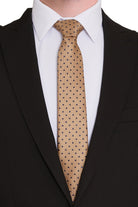 A tan tie with black polka dots, featuring a subtle textured weave.