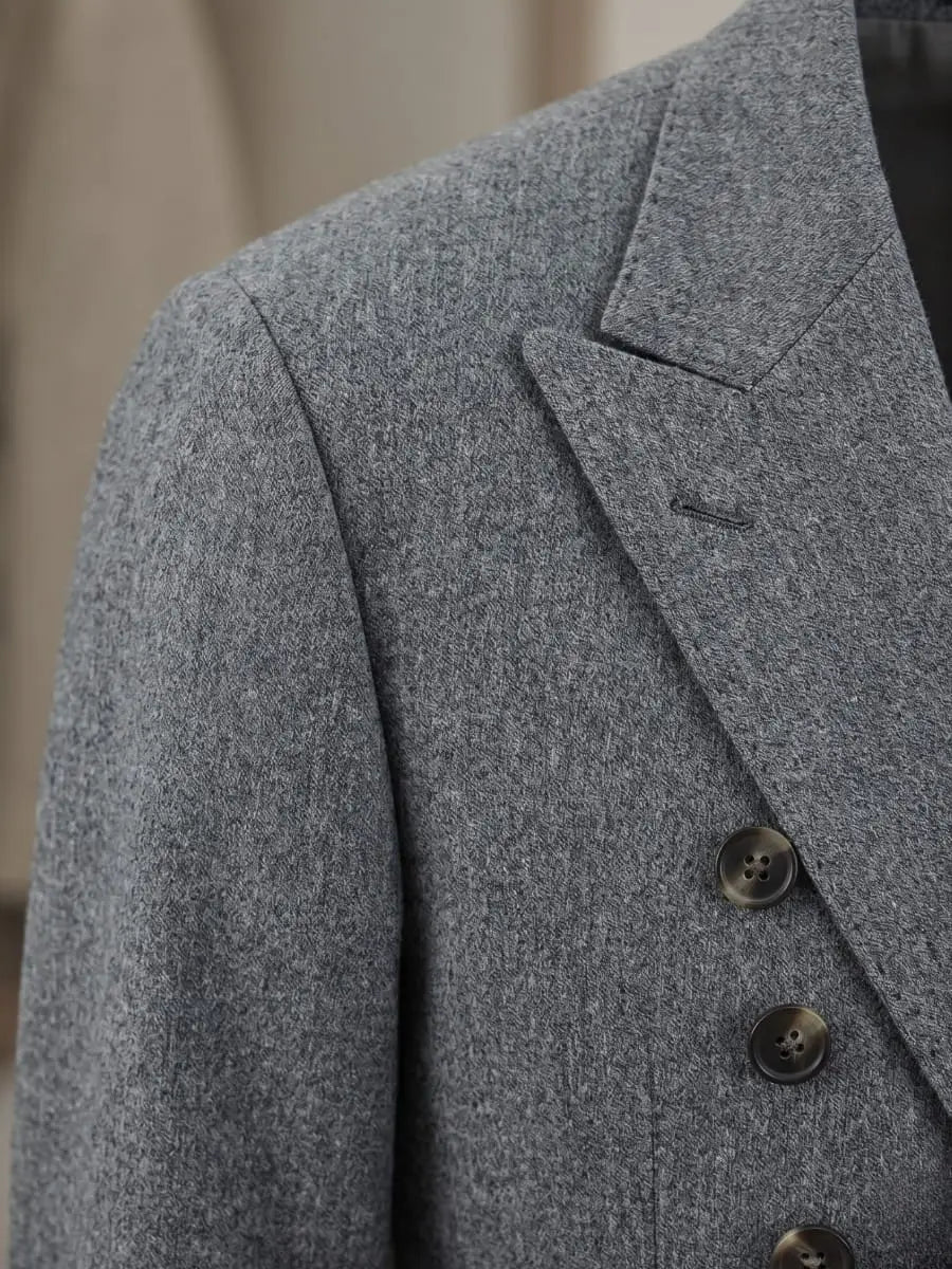 Close-up of charcoal Merino Super 130s wool suit jacket fabric showing fine tight weave with peak lapel and buttonhole detail