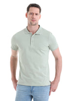 A man wearing a light green, short-sleeved polo shirt with a classic collar and buttoned placket.