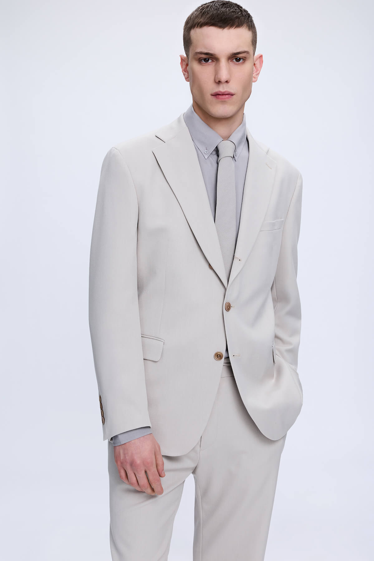 A sleek comfort fit beige two-piece suit with tailored fit and subtle texture featuring a fit beige notch lapel