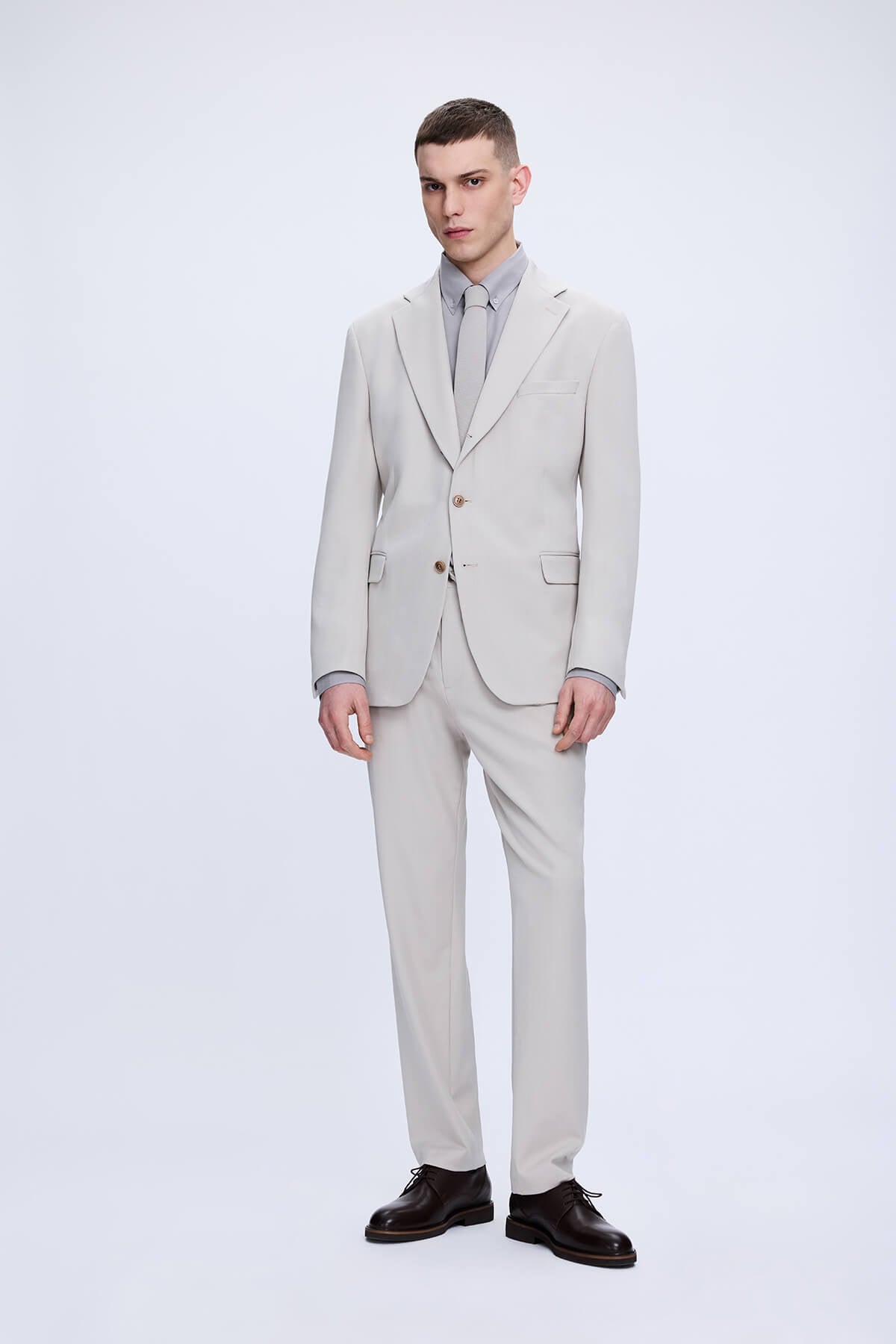 Comfort fit beige notch lapel classic suit in light gray wool with a sleek two-button design and matching trousers