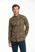 A man wearing a long-sleeved, button-up shirt with an intricate brown and beige abstract pattern.