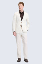 A crisp white textured wool comfort fit ecru notch lapel suit with matching trousers worn over a dark brown shirt
