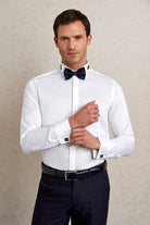 White dress shirt with a crisp, tailored fit and navy blue bow tie.