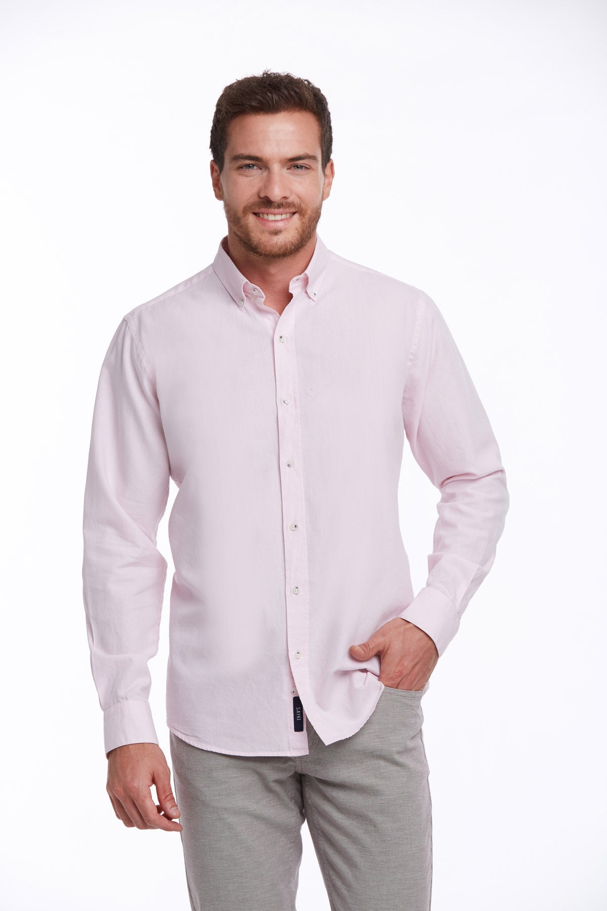 A light pink, long-sleeved button-down shirt with a classic collar and subtle texture.