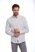 A men’s long-sleeved button-down shirt with fine vertical stripes in light gray and white, made of a smooth cotton blend fabric.