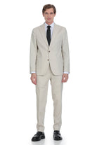 A man wearing a light beige two-piece suit with a black tie and white dress shirt.