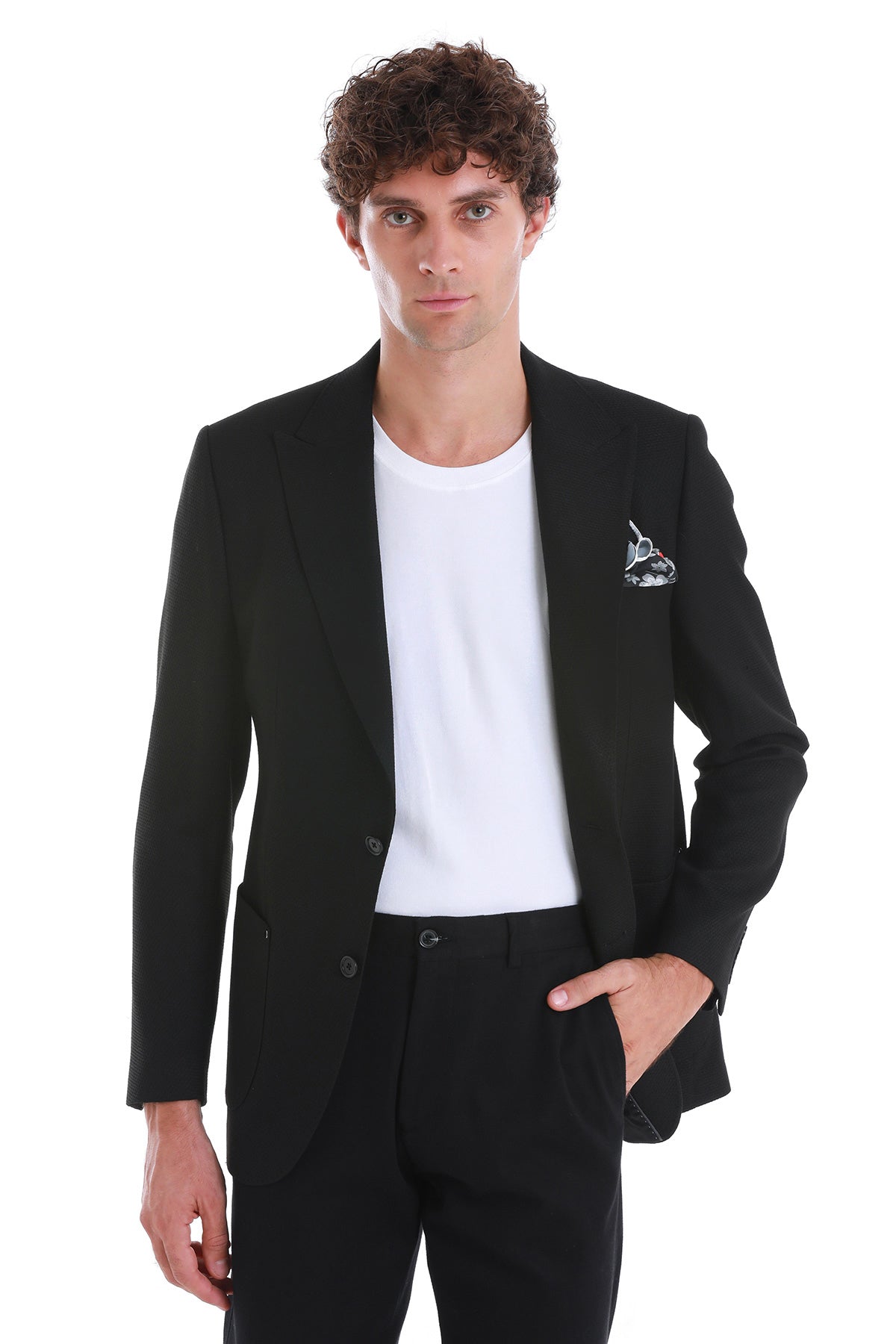 Black tailored blazer with a subtle textured weave and a white pocket square featuring a small sailboat design.