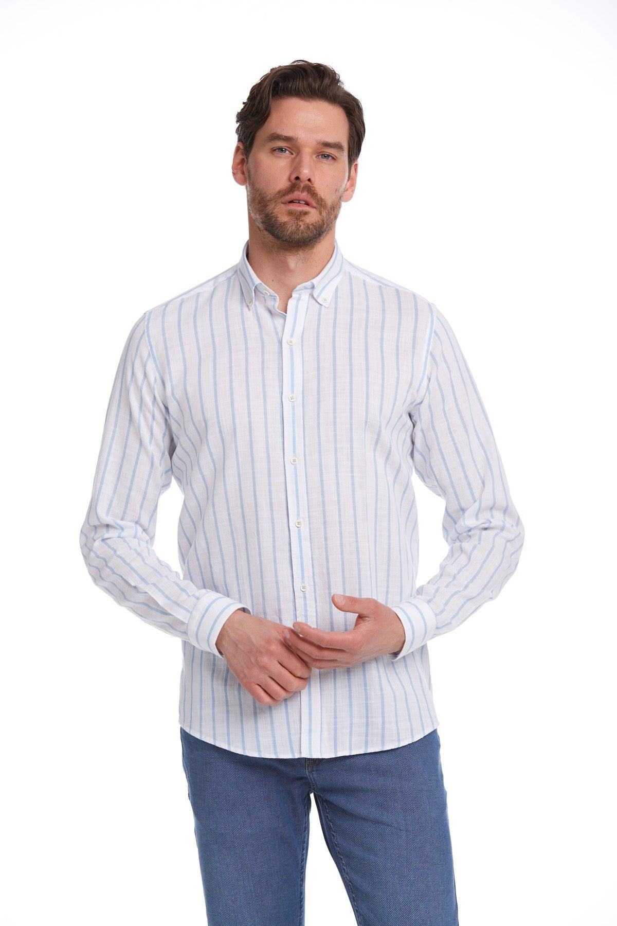 A man wearing a light blue and white vertically striped long-sleeved button-down shirt.