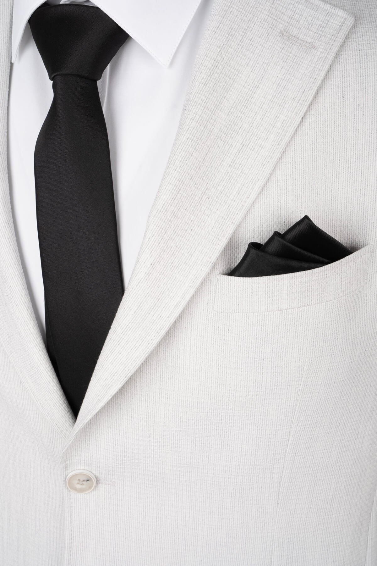 Black satin tie and matching pocket square complement a comfort fit light gray casual suit with notch lapel