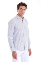 A man wearing a light blue and white vertically striped long-sleeved button-up shirt.