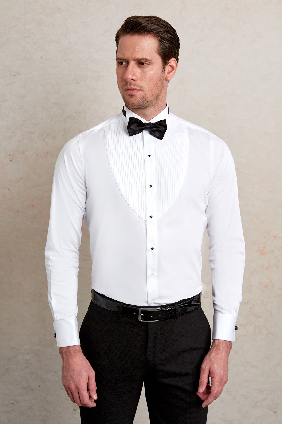 White tuxedo shirt with black bow tie and pleated front.