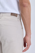 Beige textured denim dynamic fit pocket low waist casual pants with brown leather brand patch for smart casual wear