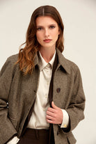 Brown houndstooth wool-blend trench coat with notched lapels and dark brown buttons.