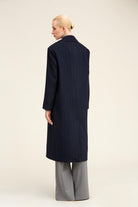 Navy blue wool overcoat with a structured collar and straight-cut silhouette