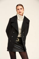 Black double-breasted wool coat with silver-toned buttons.