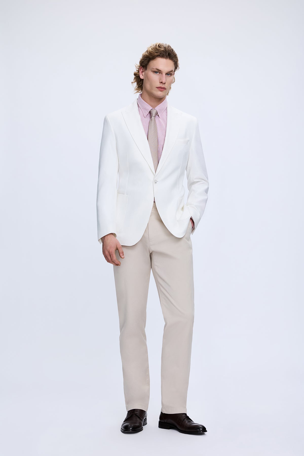 A crisp white blazer with notched lapels paired with dynamic fit double pleated stone tencel jogger pants in light beige
