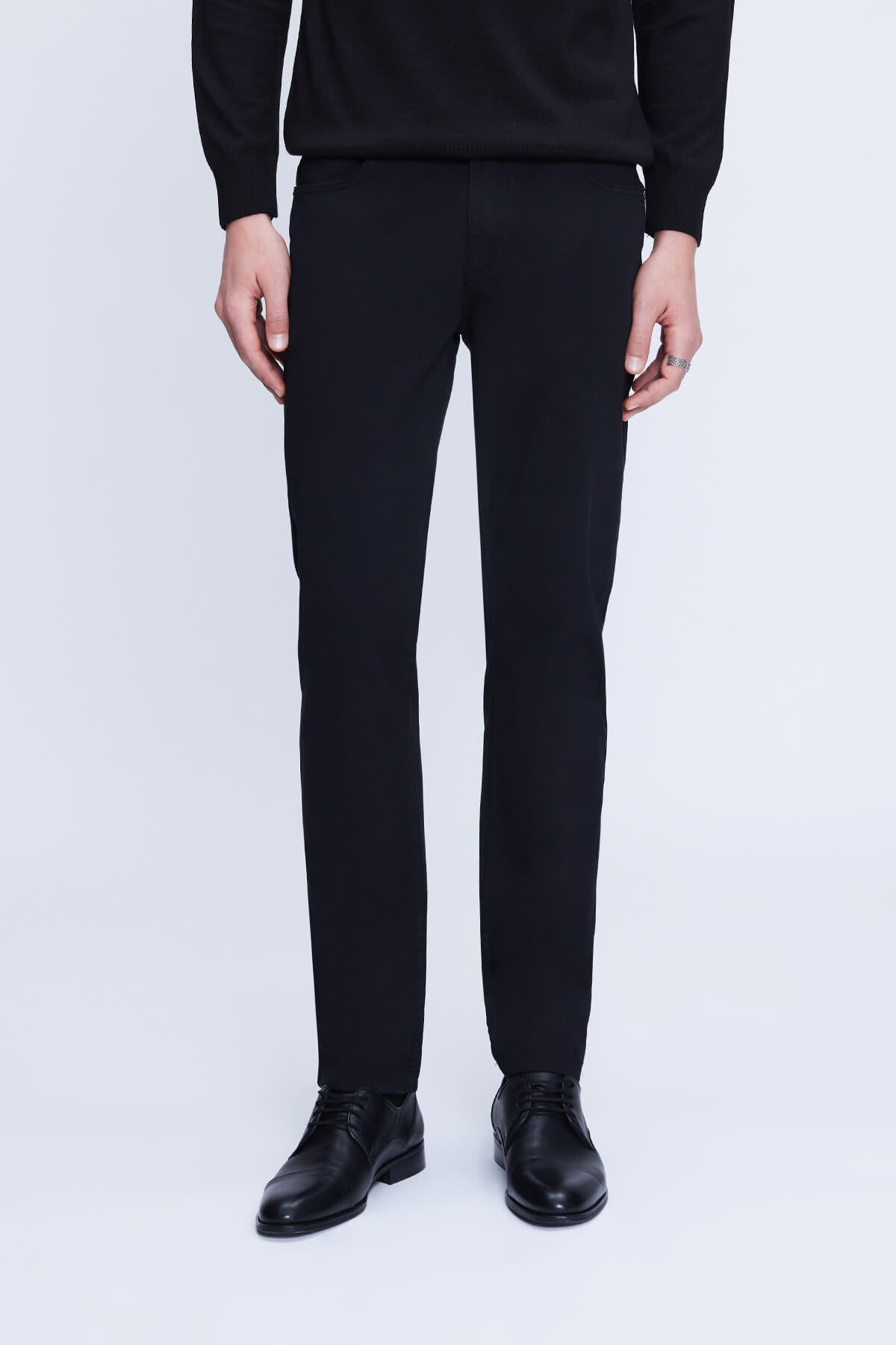 Black tailored trousers with a sleek, straight-leg cut and subtle creasing at the waistband.