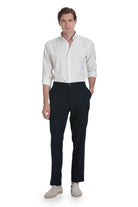 A man wearing a crisp white striped shirt with dynamic fit navy linen blend jogger pants for smart casual style