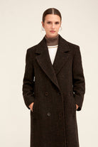 Black herringbone wool coat with a double-breasted design and dark buttons.