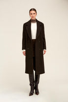 Black double-breasted wool coat with subtle glittery texture.