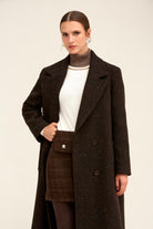 A dark brown herringbone wool coat with a double-breasted front and matching buttoned pocket.