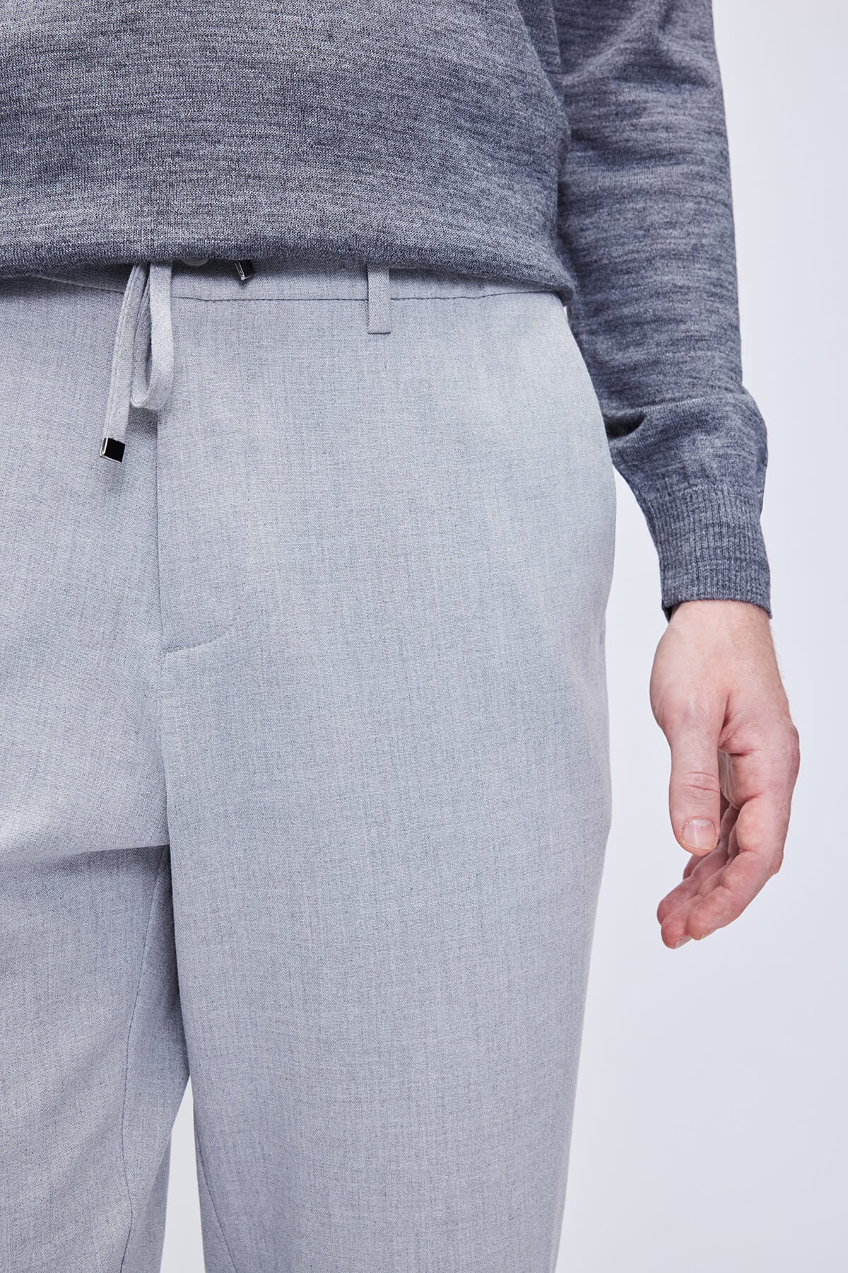 Light gray textured trousers with a drawstring waistband.
