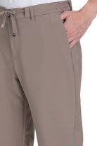 Beige chino trousers with an elastic waistband and drawstring, featuring a sleek, tailored design.