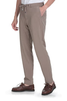 Beige tapered-fit trousers with a drawstring waistband and subtle side pockets.