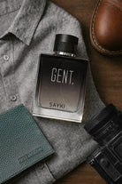 A sleek rectangular glass bottle of sayki gent men’s eau with black textured cap and gradient dark to clear liquid inside