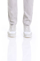 White and light gray athletic sneakers with perforated detailing on the upper.