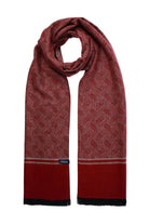 A rich burgundy scarf with a subtle woven geometric pattern and solid red bands at the ends, featuring black frayed edges.