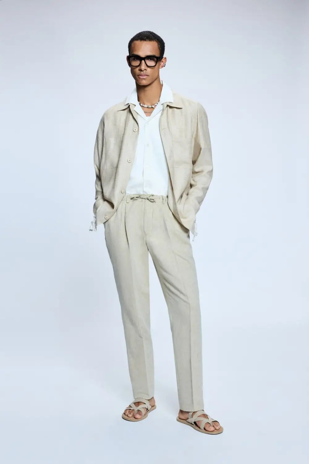 Model wearing linen suit with statement accessories