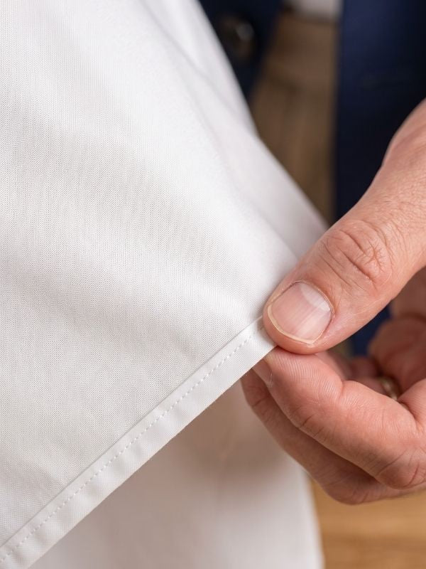 Macro detail of premium long-staple pure cotton dress shirt fabric with a smooth lustrous weave
