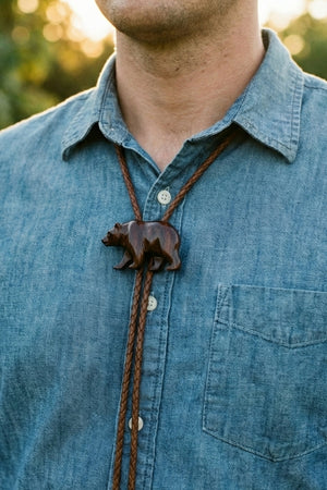 Man wearing a leather and bone bolo tie with a casual shirt