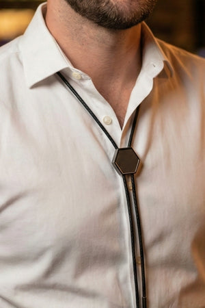 Man wearing a metal bolo tie with a dress shirt