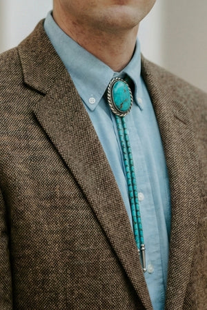 Man wearing a turquoise stone bolo tie with a blazer